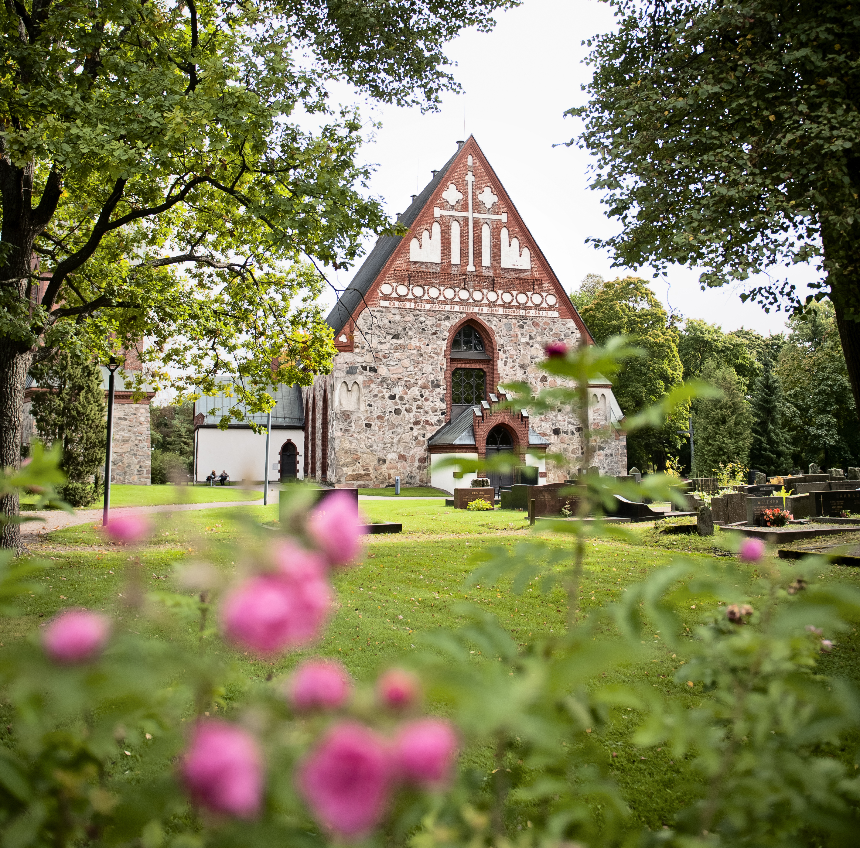 Helsinge kyrka S:t Lars med rosor i förgrunden.