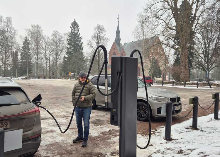 Pasi Valima laddar sin elbil vid Helsinge kyrka S:t Lars.