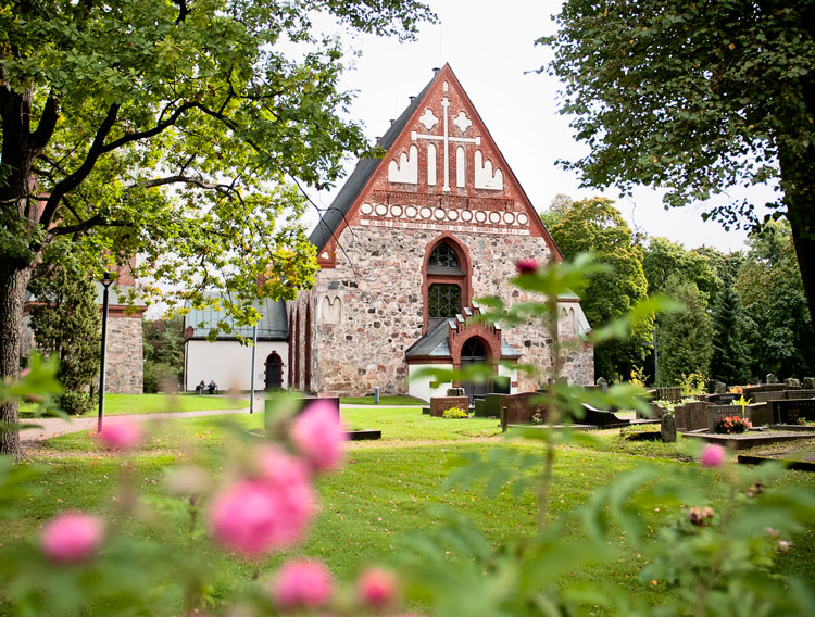 S:t Lars-vandringen Bild av Helsinge kyrka S:t Lars med blommande rosor.
