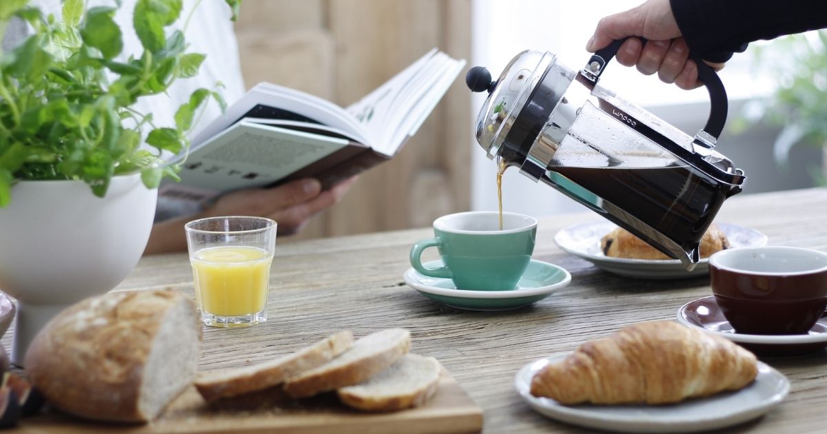 på bilden syns kaffe som hälls upp i en kopp